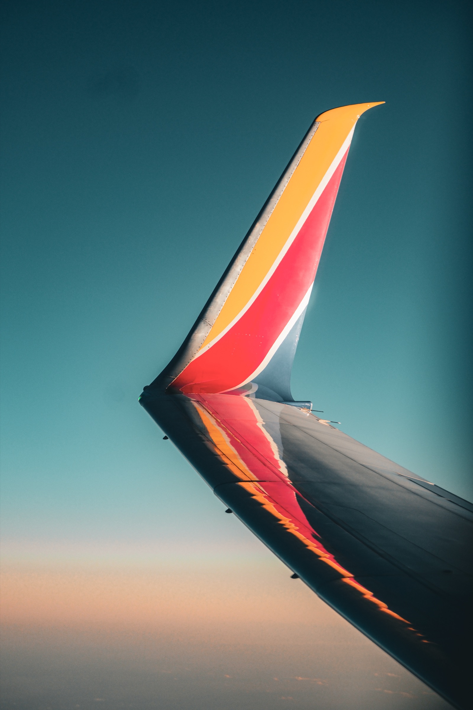 Travel - airplane wing at golden hour sunset